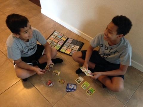 Two kids playing with their Pokémon cards