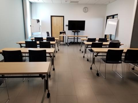 View of Yucca Room with Tables, chairs, portable monitor and white board. 