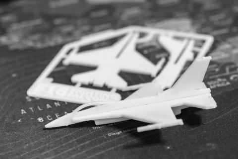 Image of a white airplane card kit over a gray background. 