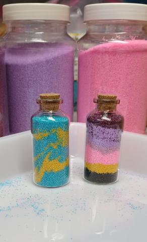 two small bottles with different color sand layers