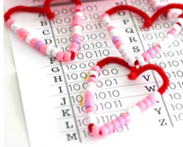 red pink and white pipecleaner hearts sitting on a binary alphabet sheet