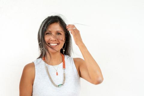 A photo of Nanibaa Beck smiling against a white background