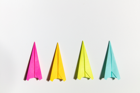 4 paper airplanes evenly spaced in a row