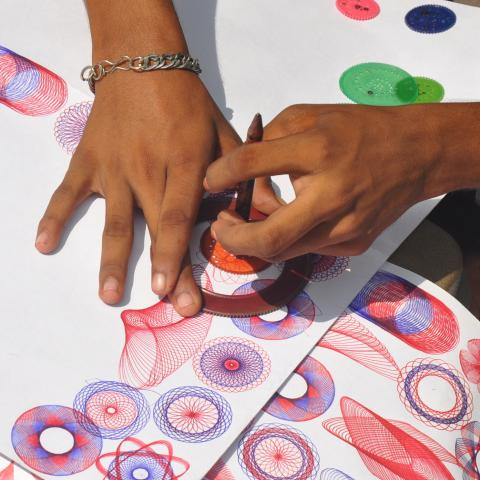 hands using a spirograph to create art