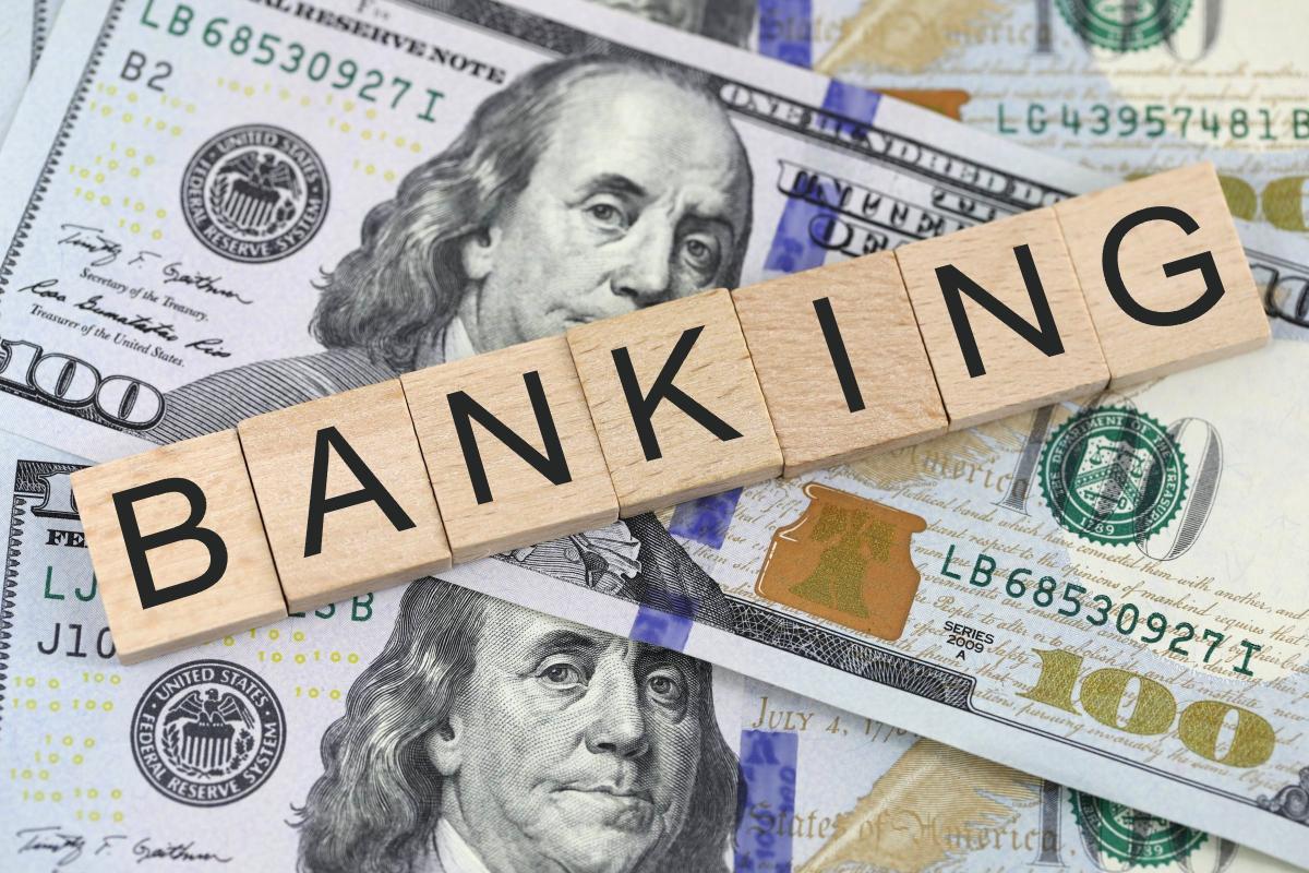 The word banking spelled with scrabble tiles on a bed of paper money