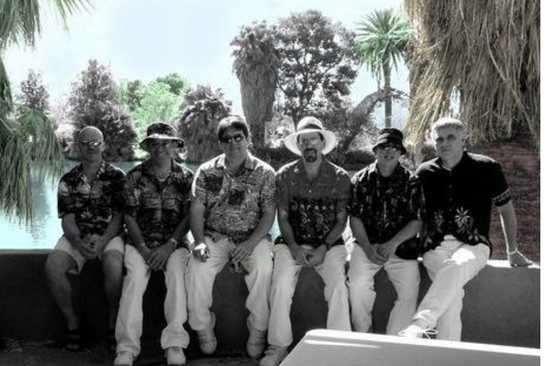 A photo of men in tropical shirts and straw fedoras