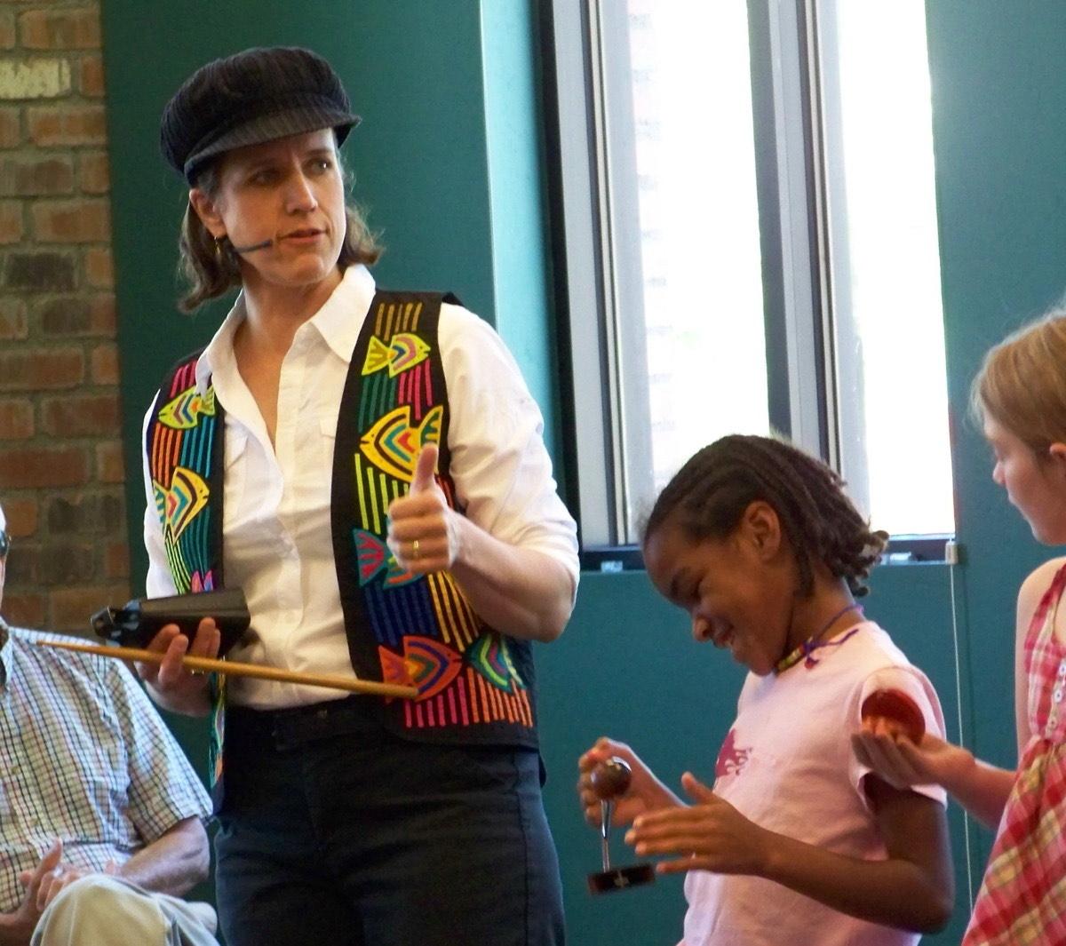 Maria thumbs-upping a child with instruments