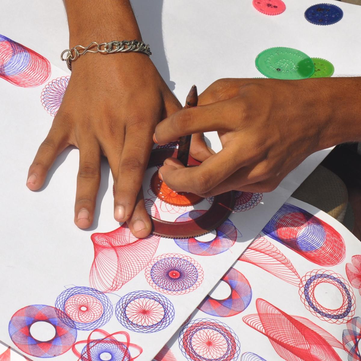 hands using a spirograph to create art